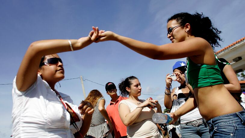 FILE PHOTO: People dance to the tune of the salsa music playing as they attend the annual Calle Ocho celebration March 11, 2007 in Miami, Florida. The event is billed as the largest Hispanic festival in the nation with reports saying that more than one million partiers attend the event every year.  (Photo by Joe Raedle/Getty Images)