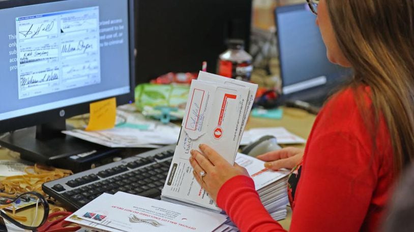 An election worker verifies signatures on mail-in ballots for the midterm elections on November 6, 2018.