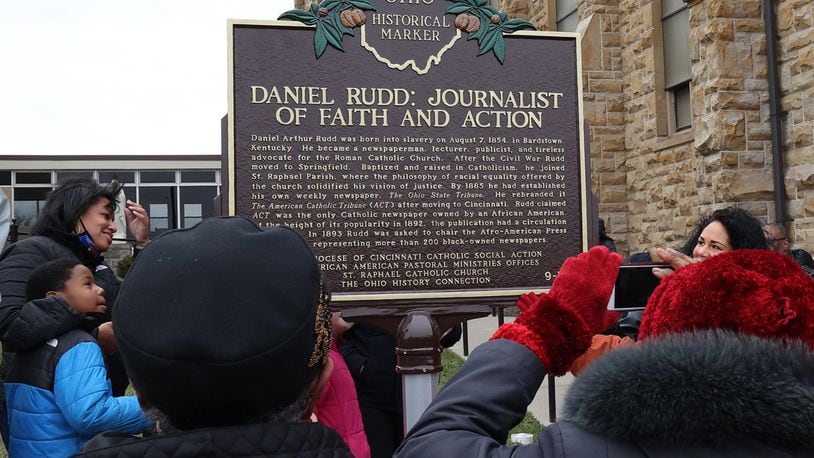 A crowd gathered outside St. Raphael Catholic Church in Springfield takes pictures of a Historic Marker that was unveiled for Daniel Rudd Sunday afternoon. Rudd, who lived in Springfield for most of his life in the late 19th and early 20th century, was an African American Catholic, a newspaper publisher and an early civil rights leader. BILL LACKEY/STAFF