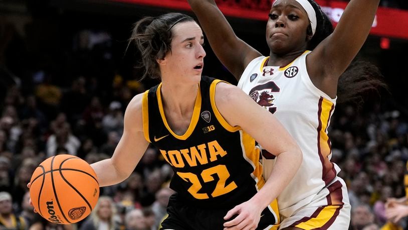 Iowa guard Caitlin Clark (22) drives around South Carolina guard Raven Johnson (25) during the second half of the Final Four college basketball championship game in the women's NCAA Tournament, Sunday, April 7, 2024, in Cleveland. (AP Photo/Morry Gash)