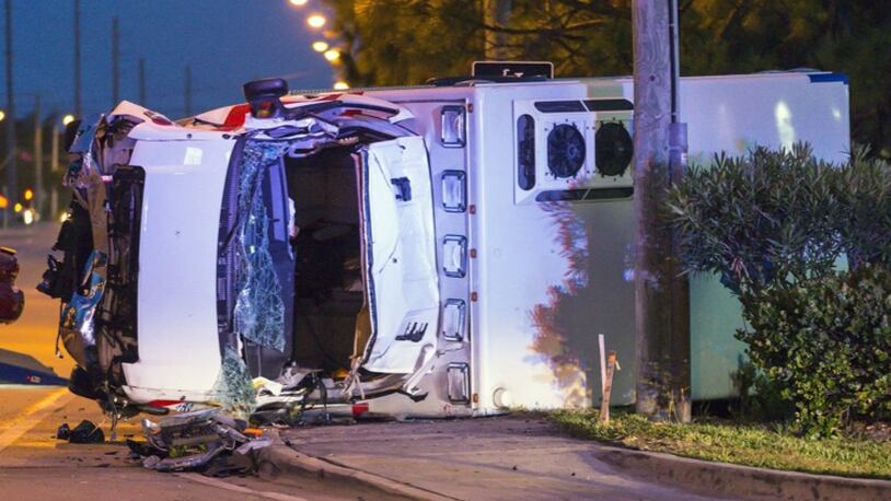 An ambulance lies on its side at the scene of a wreck where two American Medical Response ambulance employees were killed and a third person seriously injured after the ambulance hit a car and rolled over on Indiantown Road in Jupiter before dawn Thursday, June 1, 2017.