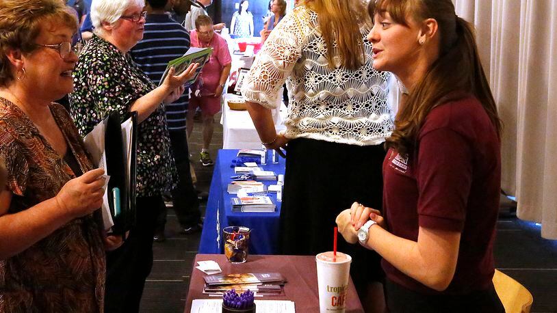 Jordan Kolar, representing the Home Instead company, right, talks to potential employees last year at the Chamber of Greater Springfield and OhioMeansJobs Clark County job fair. Bill Lackey/Staff