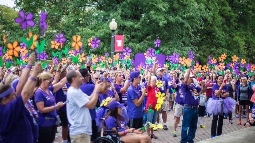 Registration is now open for this year’s five Miami Valley Chapter Walk to End Alzheimer’s, including the walk in Springfield. Here, Springfield Walk to End Alzheimer's participants hold their flowers in the air during the Promise Garden ceremony. Each flower represents a person’s connection to the disease, including whether they are a caregiver or have lost a loved one to the disease. FILE