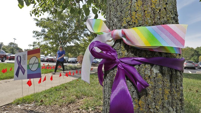 Purple ribbons are tied around trees at Clark State to bring attention to domestic violence and rainbow ribbons to stop bullying Monday. BILL LACKEY/STAFF