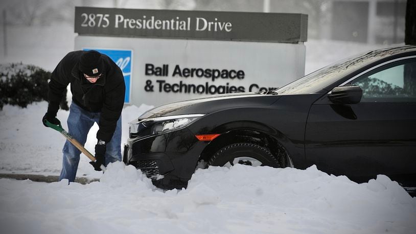 A driver shovels his way out of a snowdrift on Presidential Drive in Fairborn early Friday morning, December 23, 2022. MARSHALL GORBY \STAFF