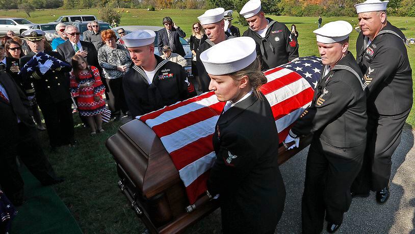 Members of a Navy honor guard carry the remains of William “Billy” Welch to the grave site at Calvary Cemetery. Welch was killed 75 years ago during the bombing of Pearl Harbor and his remains were just recently identified. Welch, who attended Catholic Central High School, was buried with full military honors Saturday. Bill Lackey was nominated for an Ohio APME award for this photo. Bill Lackey/Staff