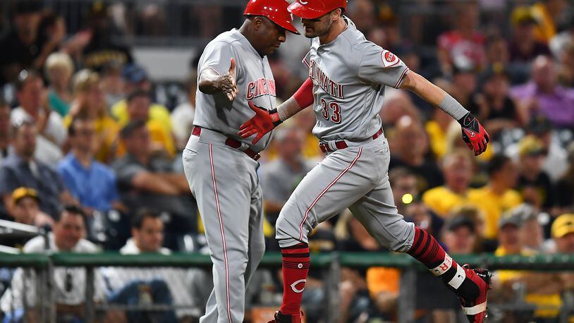 Reds rookie outfielder Jesse Winker celebrates his solo home run with third base coach Billy Hatcher during the seventh inning against the Pirates at PNC Park on Wednesday night.