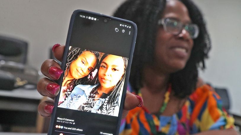 Stacy Cameron of Springfield holds up her cellphone, showing a photo of her and her daughter Shauna Cameron, Wednesday, May 18, 2022. Shauna was shot and killed May 8 on Mother's Day while riding in a car along U.S. 35 in Riverside. BILL LACKEY/STAFF