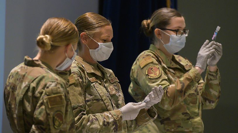 Staff Sgt. Allison Turner and Staff Sgt. Elizabeth Ciero, both with the 88th Healthcare Operations Squadron, fill syringes with the COVID-19 vaccine in the Wright-Patterson Medical Center auditorium. The Airmen were preparing the syringes to vaccinate health care workers and other Phase 1 Airmen. U.S. AIR FORCE PHOTO/R.J. ORIEZ