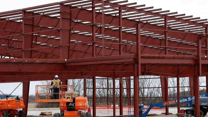 A worker maneuvers a lift into place as work continues on the National Advanced Air Mobility Center of Excellence at the Springfield Beckley Airport Thursday, Feb. 16, 2023. BILL LACKEY/STAFF