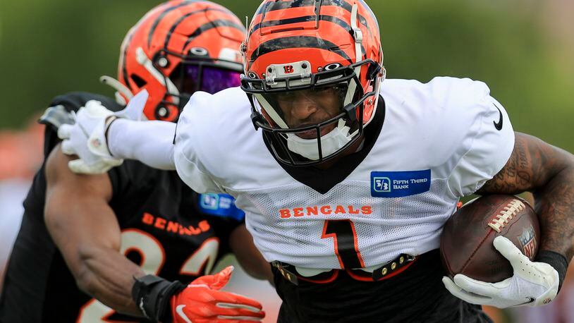 Cincinnati Bengals' Ja'Marr Chase (1) makes a catch against Chidobe Awuzie in a drill during an NFL football practice in Cincinnati, Tuesday, Aug. 3, 2021. (AP Photo/Aaron Doster)