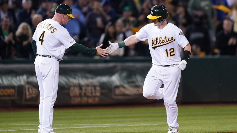 OAKLAND, CALIFORNIA - SEPTEMBER 04: Sean Murphy #12 of the Oakland Athletics is congratulated by third base coach Matt Williams #4 after Murphy hit a solo home run against the Los Angeles Angels of Anaheim in the bottom of the fifth inning at Ring Central Coliseum on September 04, 2019 in Oakland, California. The home run was Murphy's first career hit. (Photo by Thearon W. Henderson/Getty Images)