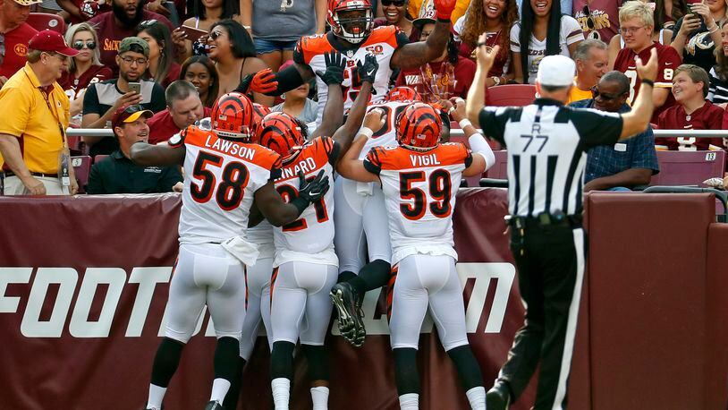 Cincinnati Bengals outside linebacker Vontaze Burfict, top, celebrates with teammates after intercepting a pass by Washington Redskins quarterback Kirk Cousins and scoring a touchdown in the first half of a preseason NFL football game, Sunday, Aug. 27, 2017, in Landover, Md. (AP Photo/Alex Brandon)