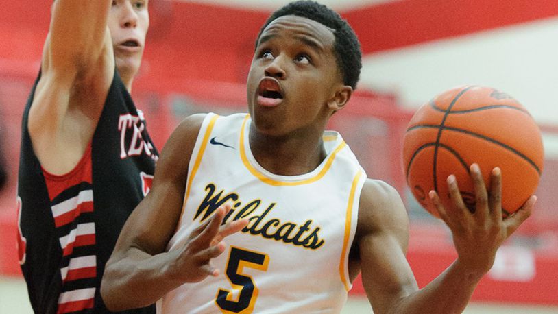 Springfield junior guard Michael Wallace shoots with pressure from Tecumseh’s Ross Warren during a sectional quarterfinal win for the Wildcats on Friday night at Trotwood. BRYANT BILLING / CONTRIBUTED