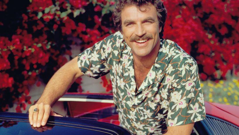 Actor Tom Selleck stars as Thomas Sullivan Magnum on the CBS television series "Magnum, P.I."  He is in a red Ferrari 308 and wearing a Hawaiian floral print shirt.  Image dated January 1, 1984. (Photo by CBS via Getty Images)