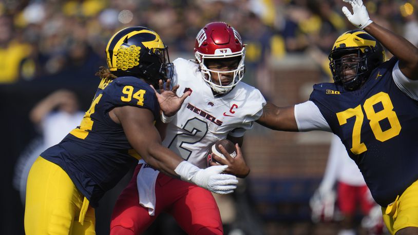 UNLV quarterback Doug Brumfield (2) is sacked by Michigan defensive linemen Kris Jenkins (94) and Kenneth Grant (78) in the first half of an NCAA college football game in Ann Arbor, Mich., Saturday, Sept. 9, 2023. (AP Photo/Paul Sancya)