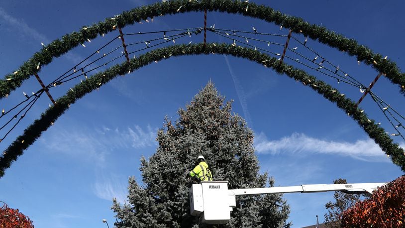 Members of the City of Springfield Service Department wrap the city's holiday tree in thousands of light on the Springfield Esplanade earlier this month in preparation of Holiday in the City. BILL LACKEY/STAFF