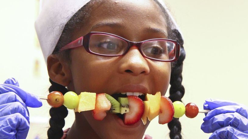 Madison Smith devours a self-made fruit kebab while taking a cooking class for teens called iCook during the “You Are What You Eat” program at St. John Missionary Baptist Church in June of 2013. Barbara J. Perenic/Staff