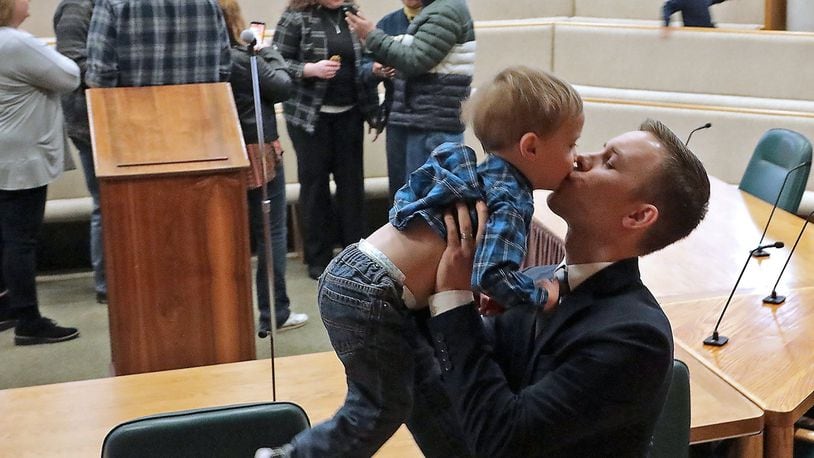 Springfield Police Officer Mattew Anderson kisses his son, Christian, 2, after he was sworn-in with six other officers during a ceremony Monday at the Springfield City Hall Forum. BILL LACKEY/STAFF