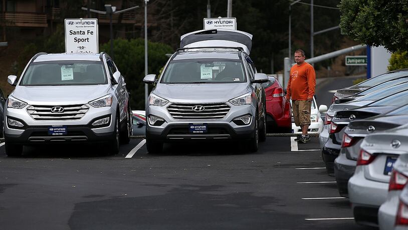A customer looks at a brand new Hyundai Santa Fe mid-size crossover vehicle at Hyundai Serramonte in Colma, California.