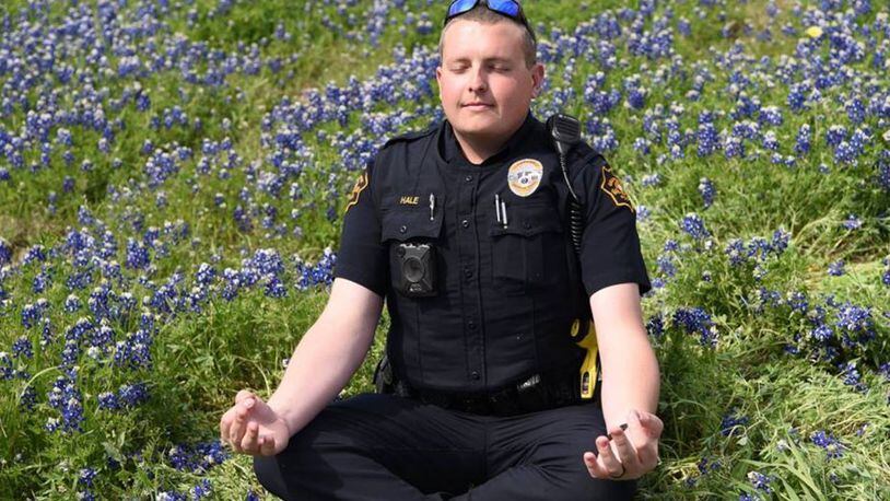 A member of the Grapevine Police Department meditates in a field of bluebonnets.