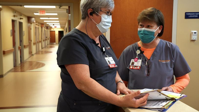Nurses confer over a patient's chart Tuesday, Jan. 4, 2022 at the Ohio Valley Surgical Hospital.  BILL LACKEY/STAFF