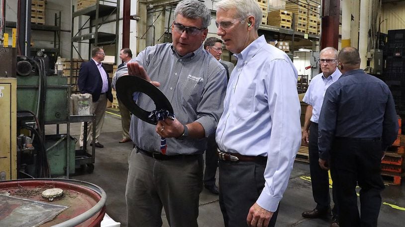 Andrew Brougher, from Morgal Machine Tool Company, shows Senator Rob Portman one of the parts the company produces Tuesday during a tour of the manufacturing plant. Senator Portman was participating in a workforce roundtable discussion hosted by the Chamber of Greater Springfield. BILL LACKEY/STAFF