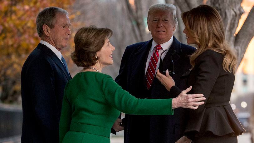 President Donald Trump, second from right, and first lady Melania Trump, right, are greeted by former President George Bush and former first lady Laura Bush outside the Blair House across the street from the White House in Washington, Tuesday, Dec. 4, 2018.