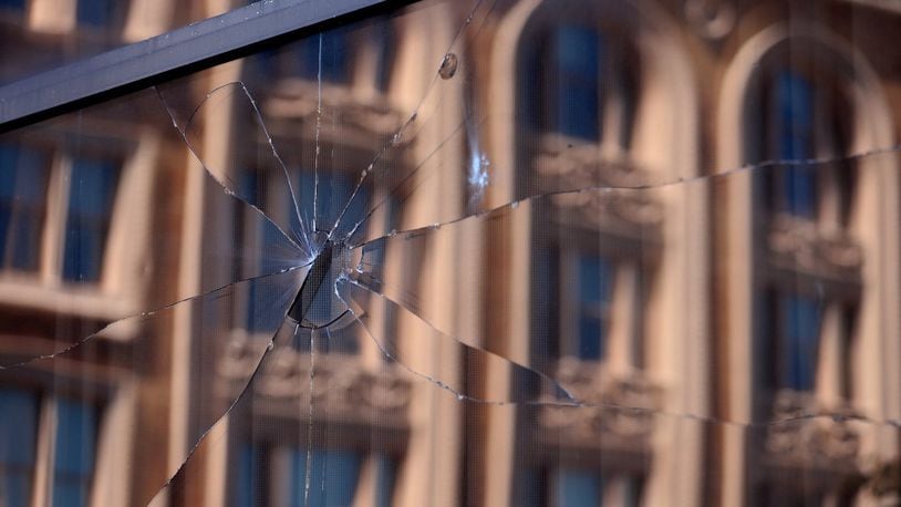 A broken window in EF Hutton Tower in downtown Springfield Monday morning. BILL LACKEY/STAFF