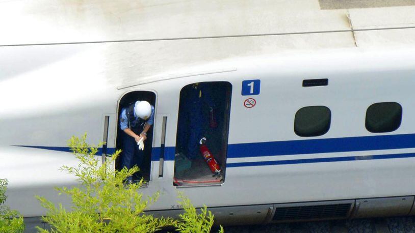 An extinguisher is left on a car of a Shinkansen bullet train which made an emergency stop in Odawara, west of Tokyo Tuesday, June 30, 2015. A passenger on the Japan's high-speed bullet train tried to set himself or herself on fire Tuesday, causing smoke to fill the carriage and forcing the train to stop, Japan�s transport ministry said. (Kyodo News via AP Photo) JAPAN OUT, MANDATORY CREDIT