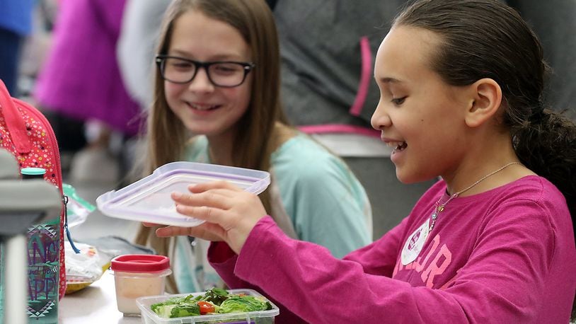Alicia Gulasa, left, and Brooklyn Bishop share a laugh during lunch at Snyder Park Elementary Friday after learning about National No One Eats Alone Day. Bill Lackey/Staff